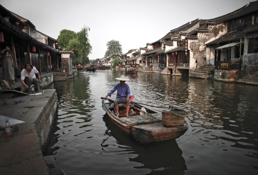 35、2011年5月16日，浙江省嘉善镇西塘，一中国男子画下了当地居民划着木船沿河经过明清.jpg