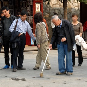 广场地书练字的老人